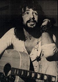 Cat Stevens sitting with guitar